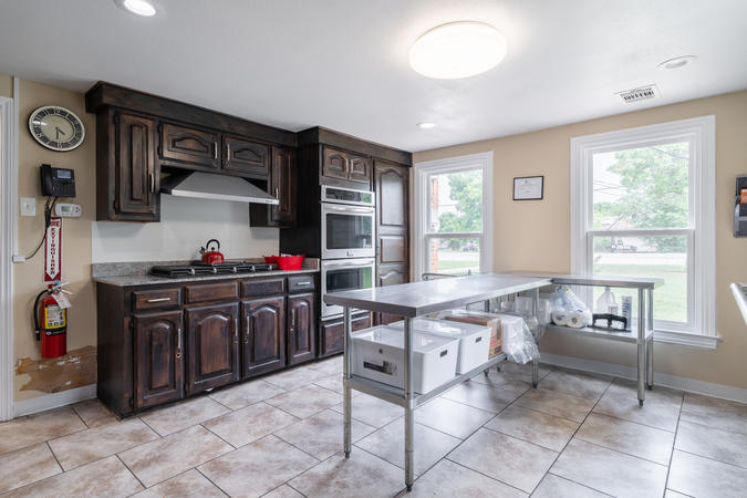 Photo of kitchen in community center, containing counters, stove, and sink