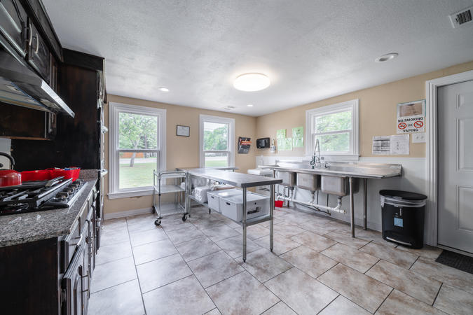 Photo of kitchen in community center, containing counters, stove, and sink